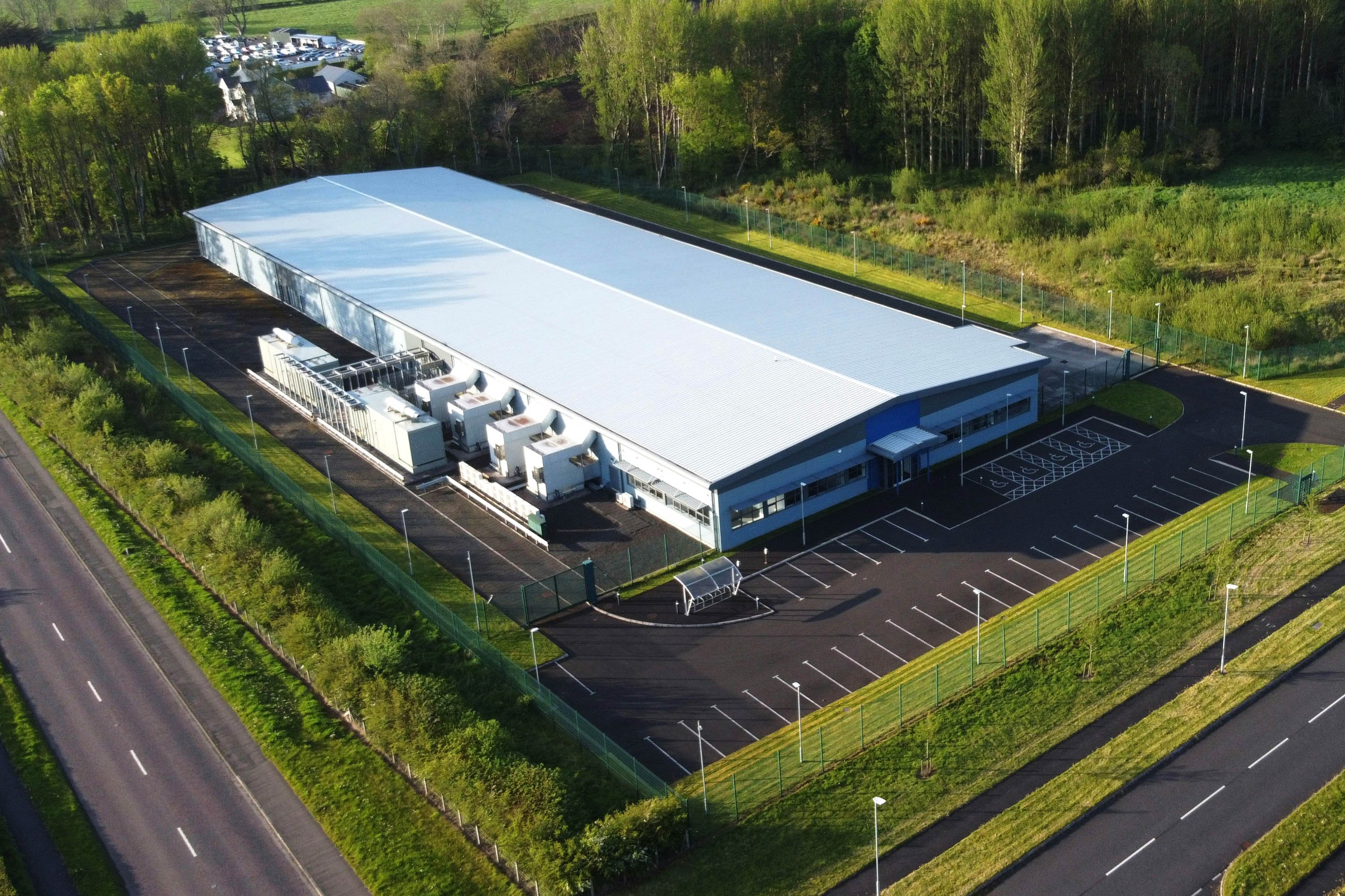 Aerial view of a data centre surrounded by roads and forests. 