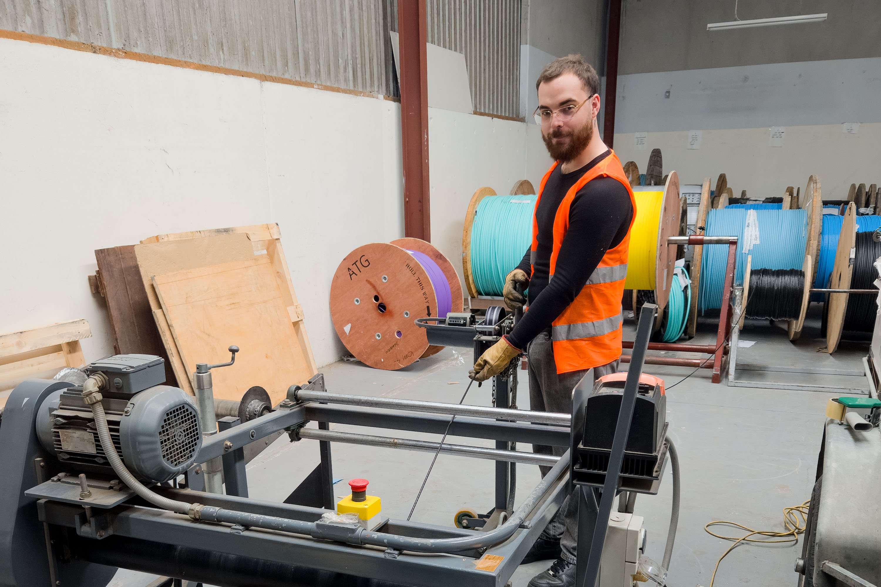 atg employee spooling a fibre cable in an industrial setting.