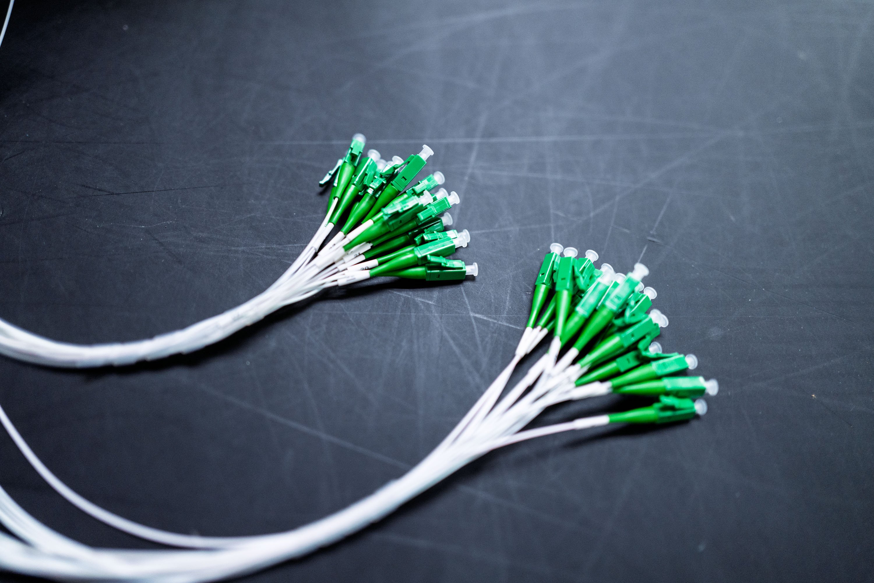 Splitter tails featuring green connectors attached to white cables.