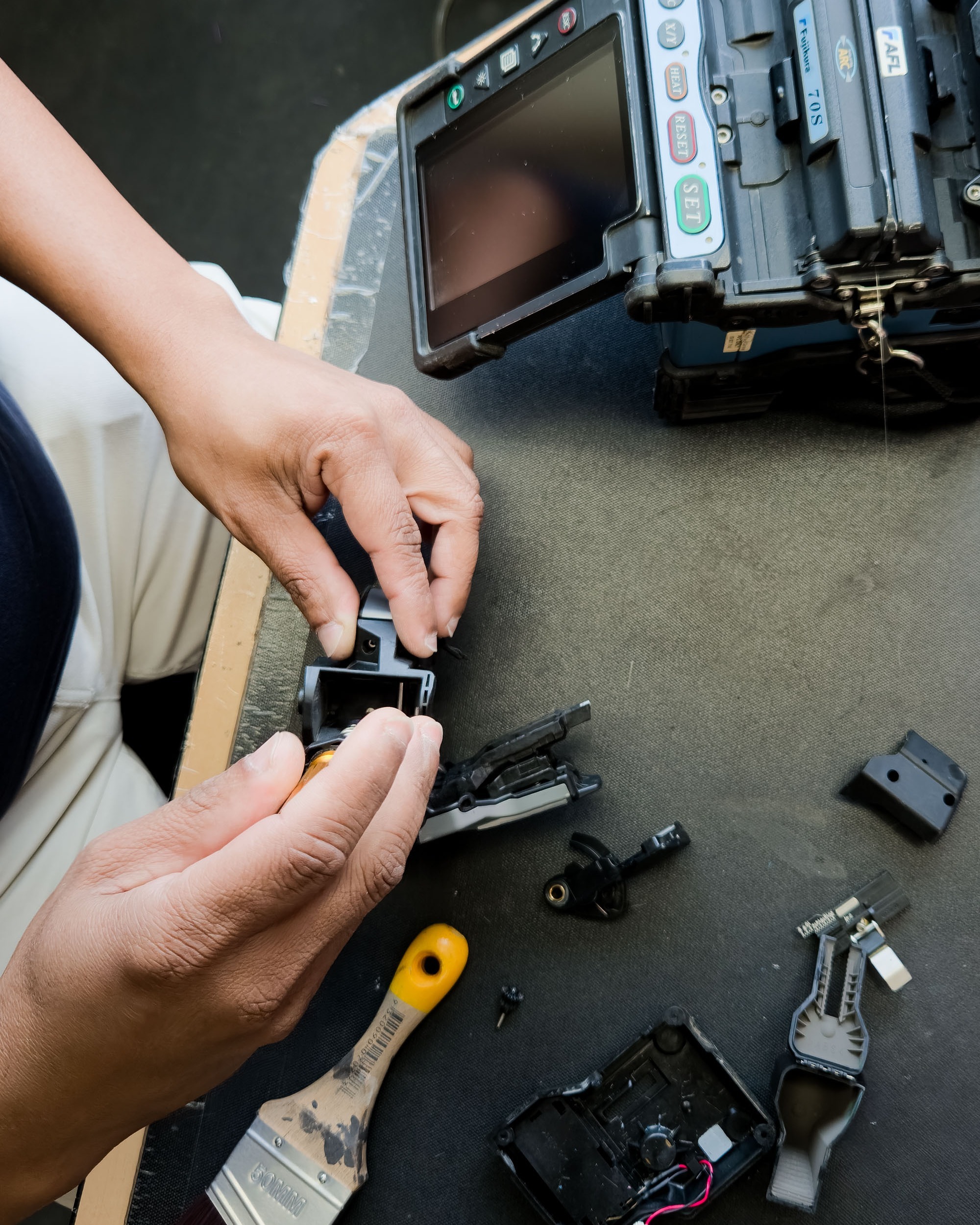 Close-up of the service work on a fibre splicing machine in an office.